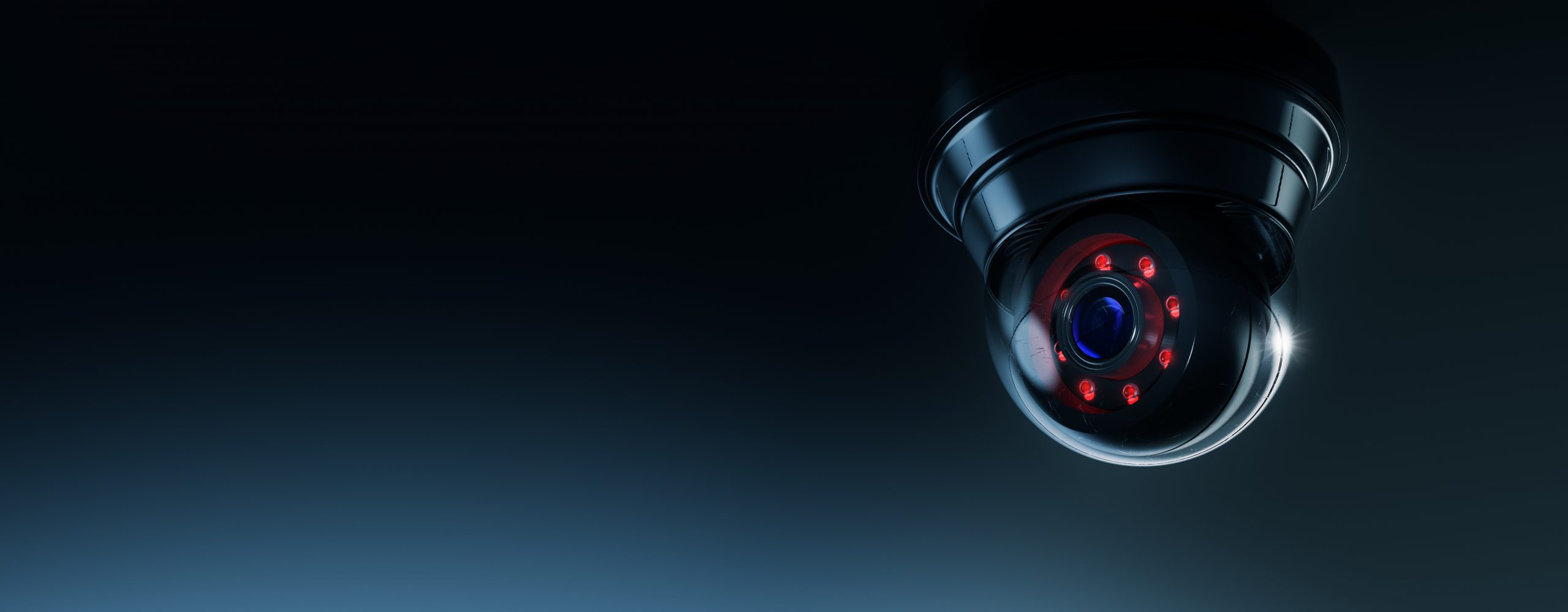 High contrast image of a surveillance camera on a dark backgroun
